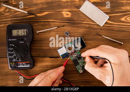 Radioelektronischer Prüfsatz für Lötdraht und Schrumpflötschlauch mit Lötmittel neben Schraubendreher und Multimeter auf Holzhintergrund, Radio e Stockfoto