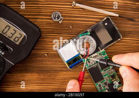 Radioelektronischer Prüfsatz für Lötdraht und Schrumpflötschlauch mit Lötmittel neben Schraubendreher und Multimeter auf Holzhintergrund, Radio e Stockfoto