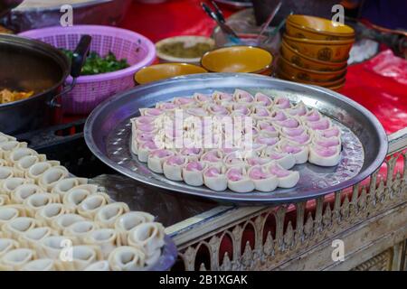 Frischer, unbehackter Wonton auf einem runden Metall-Tablett, Auch Bekannt Als Wantan oder Huntun. Mit Fleisch oder Gemüse gefülltes Gebäck. In ganz China gibt es verschiedene Varianten. Stockfoto