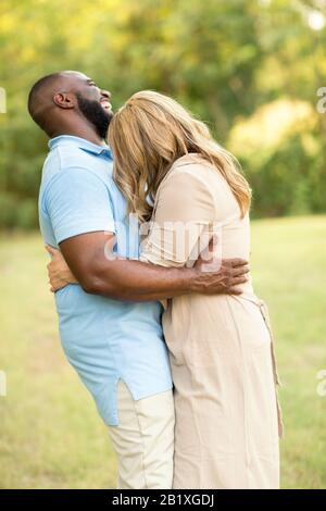 Liebevolle Mixed Race Paar umarmen und Lachen. Stockfoto