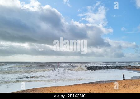 Eine einzige Person steht bei stürmischem Winterwetter an der Küste, Jura-Tradition-Küstenlinie, Ärmelkanal-Meer in West Bay, Dorset, England. Stockfoto