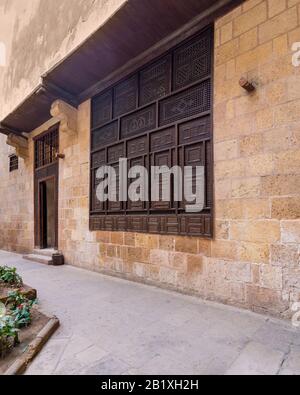 Holz-Arabeske-Fenster, Mashrabiya und Tür in Außensteinen Mauer aus stein der ottomanischen Zeit altes historisches Gebäude El Sehemy, Moez Straße, Kairo, Ägypten Stockfoto