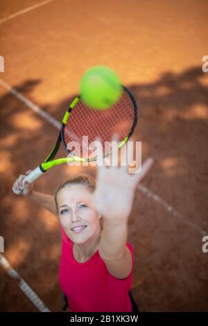 Zuversichtlich am Tennisplatz. Blick von Oben auf die attraktive junge Frau tennis player serviert auf einem Tennisplatz. Interessante POV-shot - Sportliche Mädchen Stockfoto