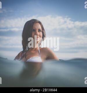Hübsche, junge Frau einen Tag am Strand genießen, Relaxen auf Luftmatratze Stockfoto