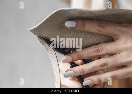 Damenhandtaschendesignerin misst Leder und schneidet Details in einem Werkstatt-Studio aus Stockfoto