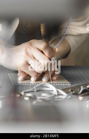 Handtaschendesignerin misst und schneidet Leder in einer Werkstatt Stockfoto