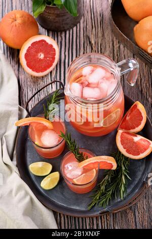 Frischer Grapefruit Cocktail. Frischer Sommercocktail mit Grapefruit, Limette, Rosmarin und Eiswürfel. Stockfoto