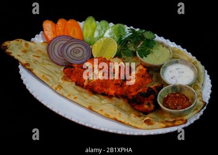 tandoori Huhn Tikka mit Chutneys, Gemüsesalaten und naanem Brot Stockfoto
