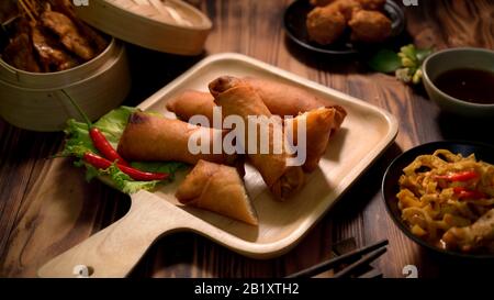 3/4-Schuss thailändisches traditionelles Straßenessen mit gebratenen Frühlingsrollen und thailändischen Vorspeisen auf dem Holzschreibtisch Stockfoto