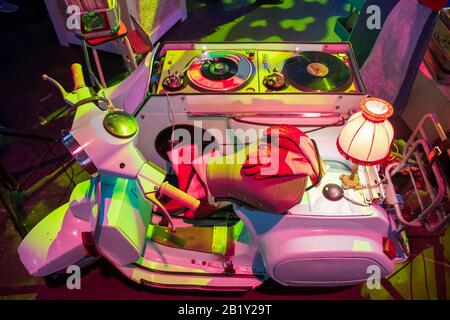 DJ-Set, Deejay-Konsole für Nachtclub oder Musikfestival mit zweisitzigen weißen Vespa-Motorrad, Lampe und Handschuhe, Vinyl-Spieler im Retro-Stil Stockfoto