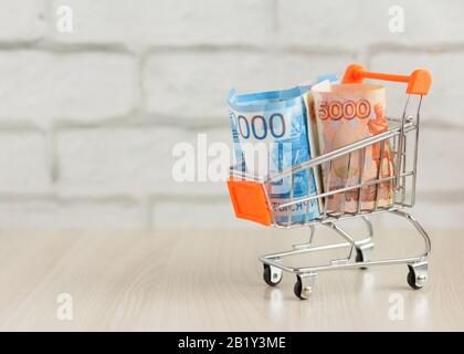 Money.Russian Money, Bills, in einem Warenkorb.The Concept of the Consumer Basket. Stockfoto