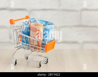 Money.Russian Money, Bills, in einem Warenkorb.The Concept of the Consumer Basket. Stockfoto