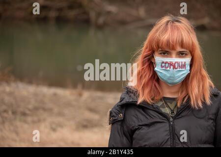 Mädchen mit medizinischer Maske, um sie vor Viren zu schützen. Coronavirus-Pandemie. Frau mit Maske stehend. Menschen, die ins Krankenhaus eingeliefert, diagnostiziert und oft eingesteckt werden Stockfoto