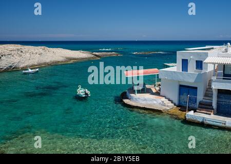 Griechenland Insel Milos. Kleiner Hafen mit Fischerbooten im Wasser, weiß getünchtes Haus. Mitakas Dorf Stockfoto
