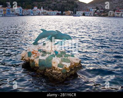 Abendstimmung auf der Insel Meis, auch Kastellorizo, Delfin-Statue im Hafen der Insel Meis, Südägäis, Griechenland Stockfoto