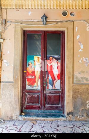 Eine alte Tür zeigt eine alte Coca-Cola-Werbung in Viareggio, Toskana, Italien. Stockfoto