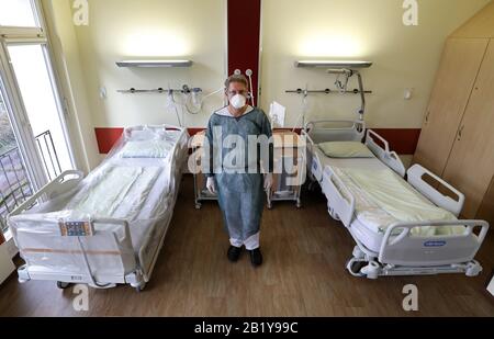 Rostock, Deutschland. Februar 2020. Der Arzt Dr. Micha Löbermann steht in Schutzkleidung in der Abteilung für Tropenmedizin, Infektionskrankheiten und Nephrologie am Zentrum für Innere Medizin des Universitätsklinikums Rostock in einem speziell präparierten Raum, in dem mögliche Covid-19-Patienten untergebracht und behandelt werden. Credit: Bernd Wüstneck / dpa-Zentralbild / dpa / Alamy Live News Stockfoto