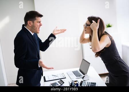 Seitenansicht Der Geschäftsleute, Die Sich Am Schreibtisch Im Büro Zerstritten Stockfoto