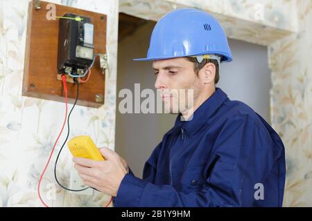 Elektriker die Messung der Spannung der Steckdose im neuen Gebäude. Stockfoto