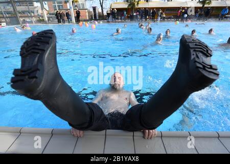 Karlsruhe, Deutschland. Februar 2020. Oma Riesterer, Besucher des Freibads "Sonnenbad", liegt bei der Eröffnung des Freibads im Wasser des Pools mit Gummistiefeln. Sonnenbaden ist laut dem städtischen Badeverband bundesweit der Beginn aller reinen Freibäder. Die Saison endet dann erst am 1. Advent. Das Wasser wird je nach Witterung bis zu 28 Grad erhitzt. Credit: Uli Deck / dpa / Alamy Live News Stockfoto