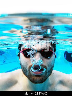 Karlsruhe, Deutschland. Februar 2020. Nicolas Kawerau, Besucher des Freibads "Sonnenbad", schwimmt bei der Eröffnung des Freibads durch das Wasser des Pools. Sonnenbaden ist laut dem städtischen Badeverband bundesweit der Beginn aller reinen Freibäder. Die Saison endet dann erst am 1. Advent. Das Wasser wird je nach Witterung bis zu 28 Grad erhitzt. Credit: Uli Deck / dpa / Alamy Live News Stockfoto