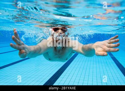 Karlsruhe, Deutschland. Februar 2020. Nicolas Kawerau, ein Besucher des Freibads "Sonnenbad", schwimmt bei der Eröffnung des Freibads durch das Wasser des Pools. Sonnenbaden ist laut dem städtischen Badeverband bundesweit der Beginn aller reinen Freibäder. Die Saison endet dann erst am 1. Advent. Das Wasser wird je nach Witterung bis zu 28 Grad erhitzt. Credit: Uli Deck / dpa / Alamy Live News Stockfoto