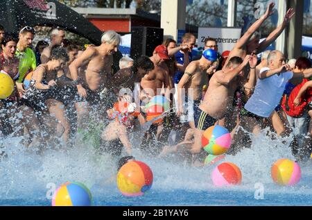 Karlsruhe, Deutschland. Februar 2020. Besucher des Freibads "Sonnenbad" springen zur Eröffnung des Freibads ins Wasser des Pools. Sonnenbaden ist laut dem städtischen Badeverband bundesweit der Beginn aller reinen Freibäder. Die Saison endet dann erst am 1. Advent. Das Wasser wird je nach Witterung bis zu 28 Grad erhitzt. Credit: Uli Deck / dpa / Alamy Live News Stockfoto