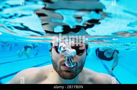 Karlsruhe, Deutschland. Februar 2020. Nicolas Kawerau, ein Besucher des Freibads "Sonnenbad", schwimmt bei der Eröffnung des Freibads durch das Wasser des Pools. Sonnenbaden ist laut dem städtischen Badeverband bundesweit der Beginn aller reinen Freibäder. Die Saison endet dann erst am 1. Advent. Das Wasser wird je nach Witterung bis zu 28 Grad erhitzt. Credit: Uli Deck / dpa / Alamy Live News Stockfoto