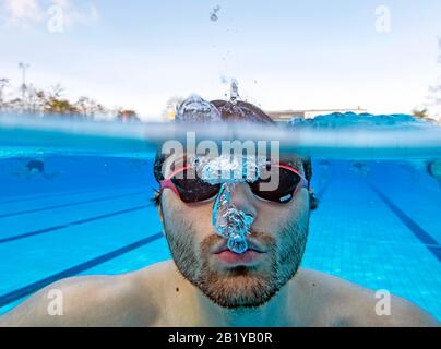 Karlsruhe, Deutschland. Februar 2020. Nicolas Kawerau, ein Besucher des Freibads "Sonnenbad", schwimmt bei der Eröffnung des Freibads durch das Wasser des Pools. Sonnenbaden ist laut dem städtischen Badeverband bundesweit der Beginn aller reinen Freibäder. Die Saison endet dann erst am 1. Advent. Das Wasser wird je nach Witterung bis zu 28 Grad erhitzt. Credit: Uli Deck / dpa / Alamy Live News Stockfoto