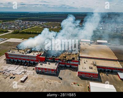 Brennendes Industrieverteilerlager, Luftdronansicht. Stockfoto