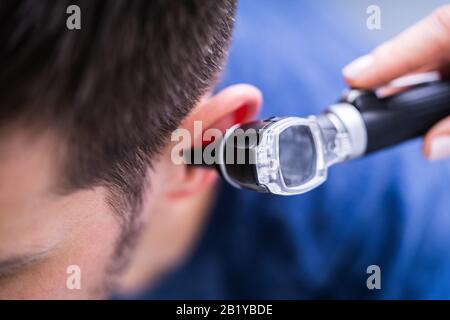 Nahaufnahme des Ohr von einer Ärztin untersuchen Patienten mit Otoskop Stockfoto
