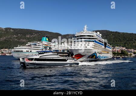 Der Schnellfahr-Katamaran Froeya (Frøya) passiert zwei Kreuzfahrtschiffe am Skolten Terminal in Bergen, Norwegen: Aidasolo und Amadea. Stockfoto