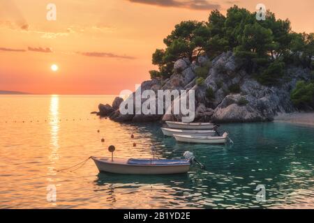 Boote auf dem Meer und grüne Bäume wachsen aus dem Felsen Stockfoto