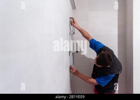 Professioneller Installateur, der in einem Bad arbeitet, Sanitäranlagen repariert, zusammengebaut und die Konzeptwerkzeuge und -Ausrüstung des Installateurs in einem Badezimmer installiert Stockfoto