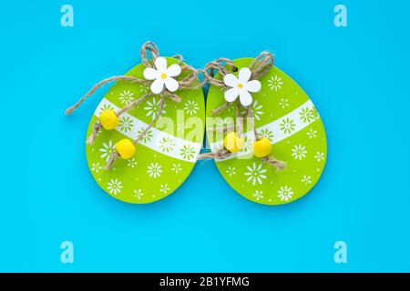 Handgefertigte ostereier auf blauem Grund. Paschalis Geschenkgutschein. Kunstdesign, Hängedekor. Blumenmuster. Frühlingsschmuck auf grünem Ei Stockfoto