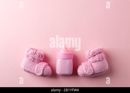 Paar kleine Babysocken auf pinkfarbenem Hintergrund mit Platz für Ihre warme Botschaft, Babydusche, Hintergrund für die erste Neugeborenenfeier, Kopierraum, niedliches Minim Stockfoto