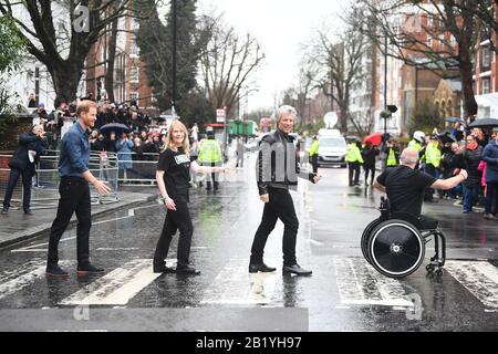 Der Herzog von Sussex, Jon Bon Jovi und Mitglieder des Invictus Games Choir gehen auf dem berühmten Zebrastreifen vor den Abbey Road Studios in London. Stockfoto