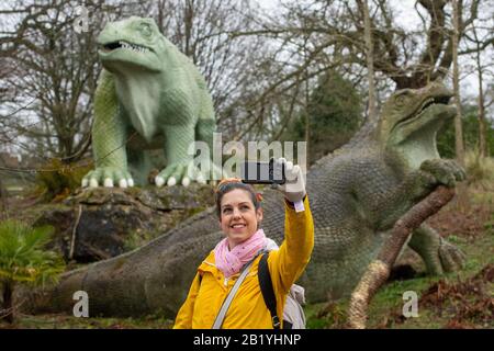 Treuhänder der Freunde von Crystal Palace Dinosaurs Sarah Slaughter nimmt ein selfie mit Iguanadon-Skulpturen, Teil der Crystal Palace Dinosuars, im Crystal Palace Park, London. Die in den 1850er Jahren errichteten 30 Grade-I-Statuen wurden in das "Heritage at Risk Register" Des Historischen Englands aufgenommen, nachdem Experten große Risse an den Körpern und Gliedmaßen und Gefahr des Verlustes von Zehen, Zähnen und Schwänzen gefunden hatten. Stockfoto