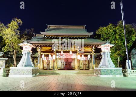 Der Nagaya-Schrein in Kobe. Nachts schloss sich das vordere Haupttor an, das von verschiedenen Lichtern mit zwei massiven Steinlaternen vor der Tür beleuchtet wurde. Stockfoto