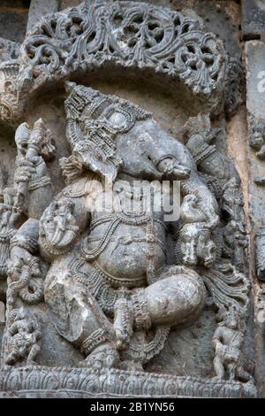 Geschnitztes Ganesha stehendes Idol an der Außenwand des Kedareshwara-Tempels, Halebidu, Karnataka, Indien Stockfoto