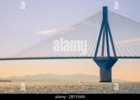 Griechenland. Bridge Rion Antirion. Hoher Pylon der Kabelbrücke über den Golf von Korinth und Motorboot an sonnigen Tagen Stockfoto