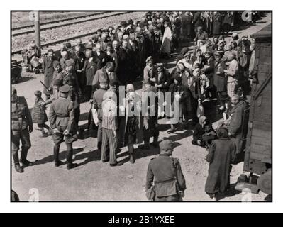 AUSCHWITZ - BIRKENAU GEFANGENEN LINE WARTESCHLANGE ANKUNFT - eine Vision der Hölle auf Erden. 1944, Nazis "Grading" (Leben oder Tod) ahnungslosen Gefangenen auf der Schiene Concourse außerhalb Eingang zum Vernichtungslager Auschwitz-Birkenau death Camp. Die berüchtigten Konzentrationslager Auschwitz wurde im Auftrag von Adolf Hitler 1940 während der Besetzung Polens durch Nazideutschland während des Zweiten Weltkrieges, die durch Heinrich Luitpold Himmler der Reichsführer der Schutzstaffel, und führendes Mitglied der Nationalsozialistischen Partei Deutschlands aktiviert gestartet Stockfoto