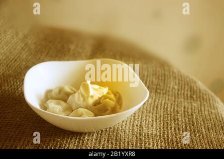 Knödelschüssel mit saurer Sahne und Butter im rustikalen Stil Stockfoto
