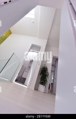 Blick auf die Decke mit Halogenstrahlern und Dachfenstern in Wohnung oder Haus. Stretchdecke weiß und komplex Stockfoto