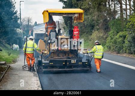 Presteigne, Powys, Wales, UK. Ein fertiger Asphalt oder Pflaster Maschine mit frischem Asphalt auf einer Straße in der Stadt Stockfoto