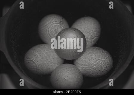 Hühnereier werden in einer Pfanne gekocht. Schwarz und Weiß. Stockfoto