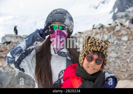 Chinse-Touristen von einem Kreuzfahrtschiff mit Kinnbinguinen; Pygoscelis antarcticus im Orne Harbour an der Danco-Küste, Graham Land, Antarc Stockfoto