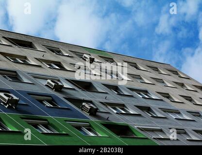 Abstrakter Blick auf Raumklimaanlagen, die auf grünen, außen isolierten Wandpaneelen an einem mehrschichigen, mittleren Wohnhaus installiert sind Stockfoto