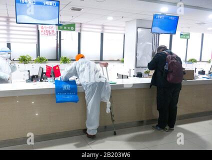 (200228) -- WUHAN, 28. Februar 2020 (Xinhua) -- Körperlich behinderter Yu Guoqiao (L) behandelt Verfahren zur Medikamenteneinnahme für behinderte Patienten einer Gemeinde in einem Drogengeschäft in Wuhan, der zentralchinesischen Provinz Hubei, 27. Februar 2020. Yu Guoqiao ist Moderator einer Behinderten-Gruppe in einer Gemeinde im Hanyang-Distrikt des von Coronavirus betroffenen Wuhan. Seit dem Ausbruch des Virus hat Yu Schwierigkeiten, Medikamente für die fast 300 behinderten Patienten der Gemeinschaft insistent zu nehmen. Er sagte, er würde an seiner Position festhalten, ständig den Behinderten zu dienen. (Xinhua/Cai Yang) Stockfoto