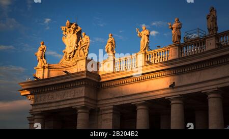 Panoramadetails der Statuen von Heiligen auf dem Petersplatz mit einem warmen Licht eines Sommernachmittags. Città del Vaticano, Italien. Stockfoto